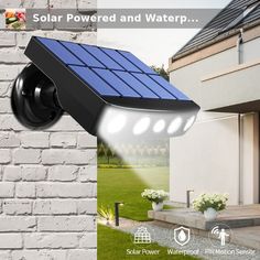 the solar powered security camera is on display in front of a white brick wall and green grass