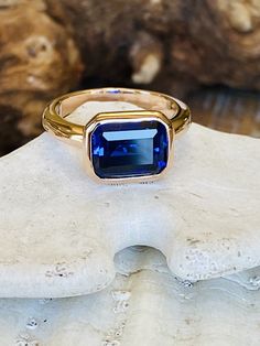 This classic east west bezel setting contains a beautiful 3.00ct lab created sapphire. The emerald cut stone measures approximately 10x8mm. The ring is available in a satin or high polish finish. The ring is available in sterling silver, and 14k white, yellow, or rose gold. Sapphire is the birthstone for September. Please send me a message if you need a size not listed. * This ring can be customized with any color center stone. All items are handmade by me in my shop in Manalapan, NJ. Please mes East West Sapphire Engagement Ring, Bezel Set Sapphire Ring, Modern Blue Sapphire Ring, Bezel Sapphire Ring, Sapphire Bezel Ring, Emerald Cut Sapphire Ring, Sapphire Gold Ring, Gems Ring, Golden Rings