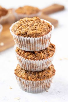 three muffins stacked on top of each other with oats in the background