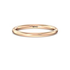 a rose gold wedding band with the word wwc engraved on it's side