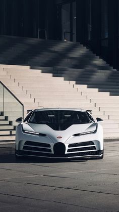 a white sports car parked in front of some steps