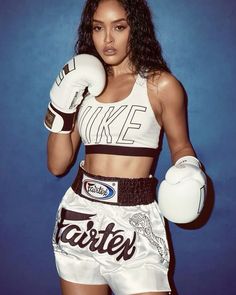 a beautiful young woman wearing boxing gloves and holding a white glove in her right hand