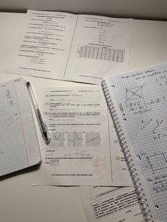 notebooks and calculators on top of a table with graph paper in the background