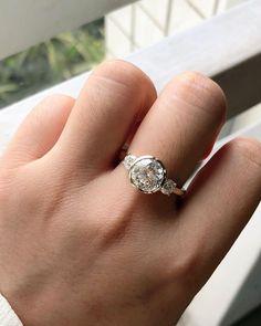 a woman's hand with a diamond ring on it