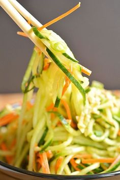 a close up of a bowl of food with chopsticks sticking out of it