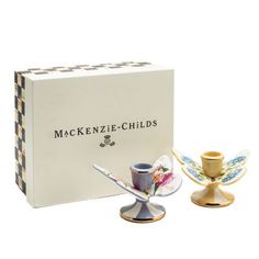 two teacups and saucers in front of a boxed box with the words mackenze - child's written on it