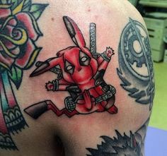 a man with tattoos on his arm and shoulder has a deadpool tattoo on it