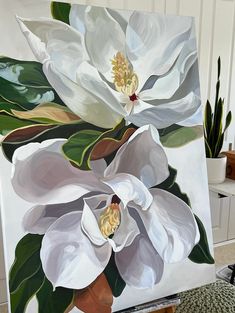 a large white flower painting on an easel