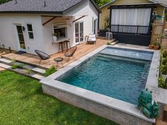 a small backyard with a pool and decking in the grass next to a house