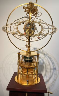 a golden clock on top of a wooden stand