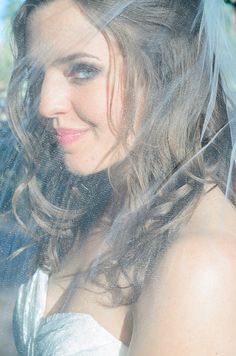 a woman wearing a veil in the back seat of a car with her hair blowing in the wind