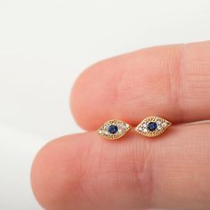 "Tiny and sparkly, these dainty evil eye studs can be worn solo for a delicate and subtle look but are also perfect for mixing and matching with other minimal studs and small hoop earrings. ∙ Sold individually (1 stud) or as a pair (2 studs). * D E T A I L S * ∙ Material: .925 Sterling Silver o r 18K Gold Plated over .925 Sterling Silver ∙ Stone: White and Dark Blue Zirconia ∙ Dimensions: 6mm (w) x 3mm (h) ∙ Come with butterfly backs ∙ Hypoallergenic & nickel-free * P A C K A G I N G * ∙ All Elegant Gold Plated Evil Eye Earrings, Dainty Gold Earrings With Diamond Eyes, Gold Plated Evil Eye Elegant Earrings, Elegant Gold-plated Evil Eye Earrings, Studs Gold Earrings, Tiny Gold Earrings, Tiny Gold Studs, Studs Gold, Gold Eyes