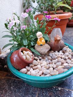 a potted planter filled with rocks and small figurines sitting on top of it