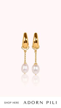 a pair of earrings with pearls hanging from the end of each ear, on a white background