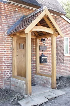 an old brick building with a wooden door and bell on the front porch next to it