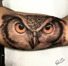 an owl with orange eyes is on the arm