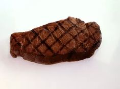 a piece of steak sitting on top of a white table