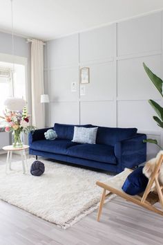 a living room with a blue couch and white rug