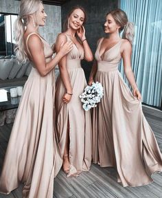 three beautiful women standing next to each other in long brown dresses and holding bouquets