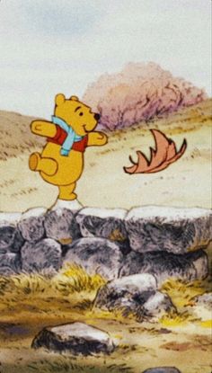 winnie the pooh flying over rocks with an orange bird in it's hand