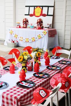 a table set up with red and white checkered tables cloths, sunflowers and plates