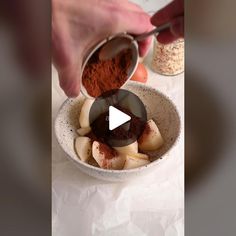 a person pouring spices into a bowl filled with food