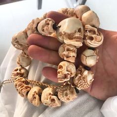 a hand holding a bracelet with skulls on it