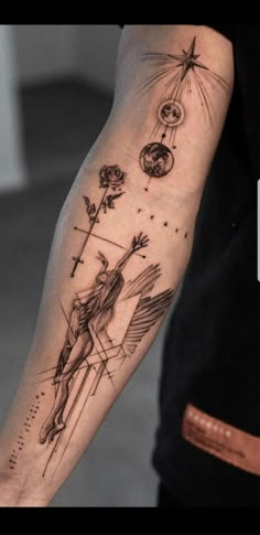 a man's arm with tattoos on it and an angel holding a cross in the middle