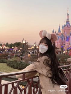 a woman wearing a face mask in front of a castle