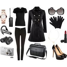 a woman's black outfit with accessories including gloves, sunglasses and camera