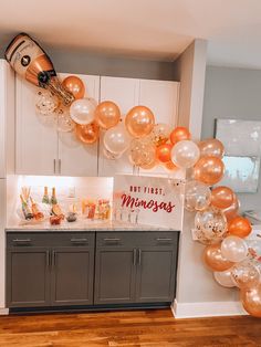 balloons and champagne are hanging from the ceiling in a kitchen area with a sign that reads, not first minnesota