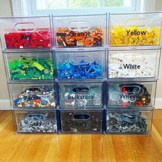 plastic storage bins filled with different types of legos and other toy items in front of a window