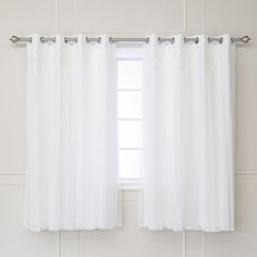 a white curtain hanging on the side of a window in front of a white wall