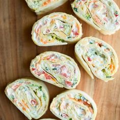 several pieces of food on a wooden surface with one cut in half and the other rolled up