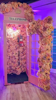 a pink phone booth decorated with flowers