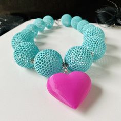 The world of 3D printed jewelry is embracing bold designs and vibrant colors, as seen in this unique creation: the Hot Pink Puffy Heart Pendant. This eye-catching piece features a mix of brutalist aesthetics with fun elements, like large aquamarine beads that add a touch of whimsy. The combination of advanced technology and artistic design results in eye-catching accessories that can enhance any outfit. These jewels not only show personal style but also reflect the innovative spirit of modern cr Fun Necklace Aesthetic, Brutalist Necklace, Pretend Jewelry, Bold Statement Necklaces, 3d Printed Jewelry, Light Weight Jewelry, Aquamarine Beads, Printed Jewelry, Puffy Heart