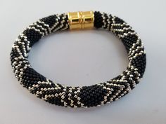 a black and white beaded bracelet with gold clasp