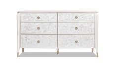 a white dresser with gold handles and drawers