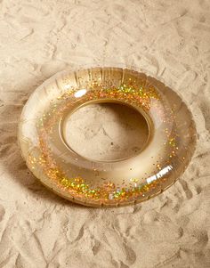 an inflatable ring on the sand with glitters and gold flecks