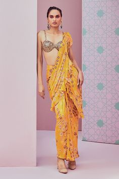 Yellow pre draped saree featuring all over jhumka patterns highlighted with ruffled border. Comes with sequin embellished blouse.
Components: 2
Pattern: Embroidered
Type Of Work: Sequin
Neckline: Sweetheart
Sleeve Type: Sleeveless
Fabric: Modal satin
Color: Yellow
Other Details: 
Cut-out blouse
Ruffle detail
Occasion: Sangeet,Cocktail - Aza Fashions Pre Draped Saree, Ruffled Saree, Draped Saree, Ruffle Saree, Yellow Saree, Drape Saree, Yellow Satin, Embellished Blouse, Stylish Sarees