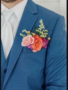 a man in a blue suit with flowers on his lapel