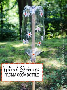 a glass bottle with flowers painted on it and the words wind spiner from a soda bottle