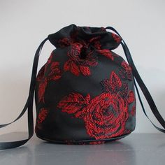 Beautiful black  satin and red rose dolly bag Handmade from lovely, medium weight  satin with a subtle sheen The bag is approx. 7" deep with a diameter of approx. 5" Great size for carrying a mobile phone, lippy, perfume or glasses etc. Base of bag is reinforced and has a piped edge. Draw strings are made from good quality double sided satin ribbon. Purse For Bride, Goth Bags, Wrist Purse, Fall Gift Baskets, Side Bags For Women, Rose Purse, Product Inspiration, Small Crafts, Prom Dance