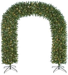 a christmas tree with lights on it in front of a white background and an arch