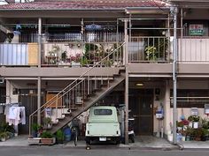 a truck parked in front of a building with stairs leading up to the second floor