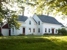 a white house sitting on top of a lush green field