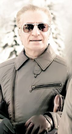 an older man wearing sunglasses and a jacket