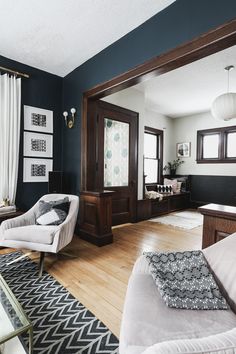 a living room with blue walls and white furniture in the center, along with wood flooring