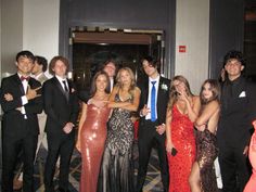 a group of people standing next to each other in front of a doorway at a formal event