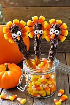 some candy sticks decorated like turkeys in a jar